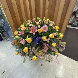 Large mixed bouquet with yellow roses, pink lilies, and purple accents