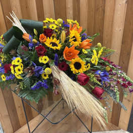 Mixed bouquet with sunflowers, roses, and lilies on a stand