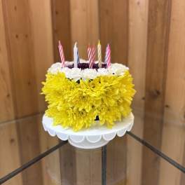 Yellow and white flower cake with striped candles on top
