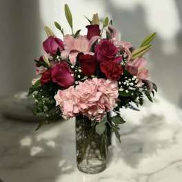 Bouquet of pink and red flowers in a clear glass vase