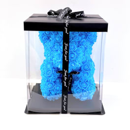Blue rose teddy bear in a clear gift box with a black ribbon