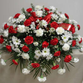 Red and white floral spray with ribbon on a table