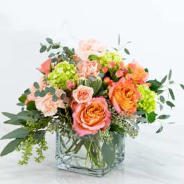 Bouquet of peach and orange roses in a clear glass vase