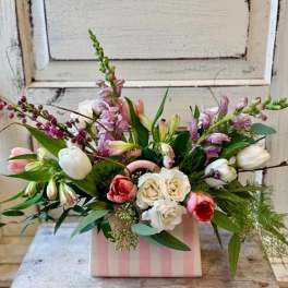 Mixed bouquet of tulips, roses, and snapdragons in a pink striped box