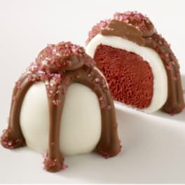 Two chocolate-dipped cake truffles with pink sugar crystals
