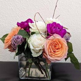 Mixed roses and carnations in a square glass vase