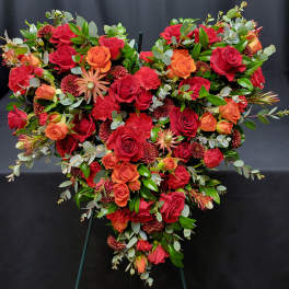 Heart-shaped floral spray with red and orange roses