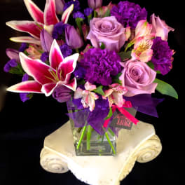 Purple and pink mixed bouquet in a clear glass vase