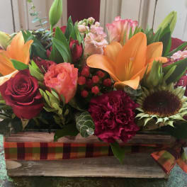 Mixed bouquet in a rustic wooden box with red roses and orange lilies