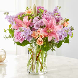 Pink and lavender flower arrangement in a clear glass vase