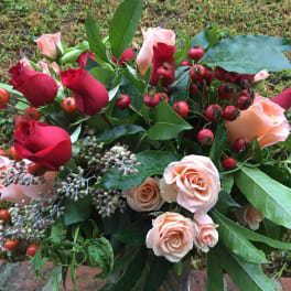 Bouquet of red and blush roses with berry accents