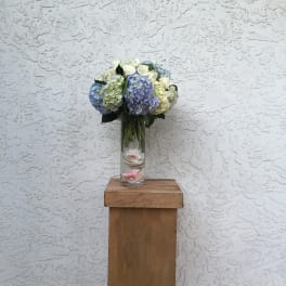 Blue and white hydrangea bouquet in a clear glass vase