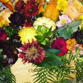 Mixed bouquet with pumpkins, roses, and chrysanthemums in a wooden box