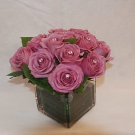 Pink roses arranged in a clear square vase