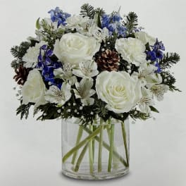 White and blue floral arrangement in a clear glass vase
