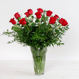 Red roses arranged in a clear glass vase