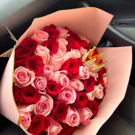 Bouquet of red and pink roses wrapped in pale pink paper