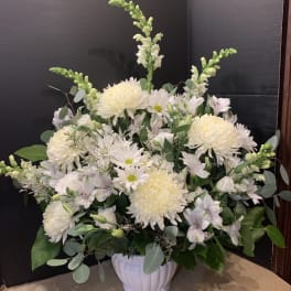 White floral arrangement in a white ceramic vase