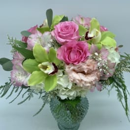 Pink roses and green orchids in a glass vase