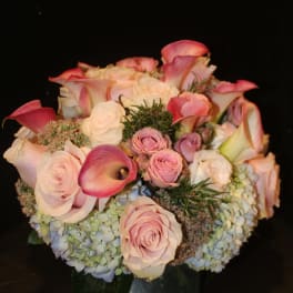 Bouquet of pink roses, calla lilies, and hydrangeas in a vase