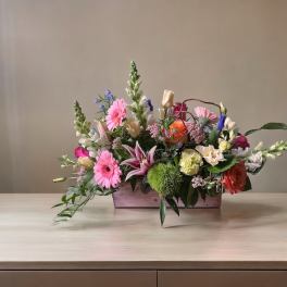 Mixed bouquet in a rectangular wooden box with pink and orange blooms
