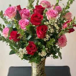 Pink and red roses arranged in a gold vase