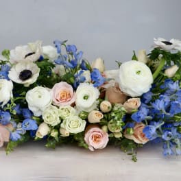 Low floral arrangement with white, pink, and blue blooms