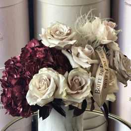 Bouquet of cream roses and burgundy hydrangeas in a round box