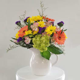 Colorful mixed bouquet in a white pitcher vase