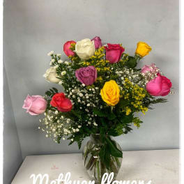 Mixed roses in a clear glass vase with baby's breath