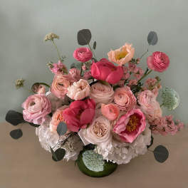 Pink and blush floral arrangement in a green vase