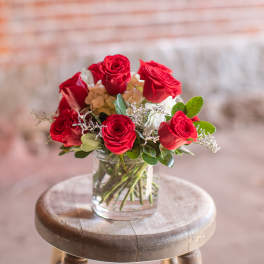 Red roses arranged in a clear glass vase