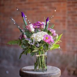 Mixed pink and white flowers arranged in a clear glass vase