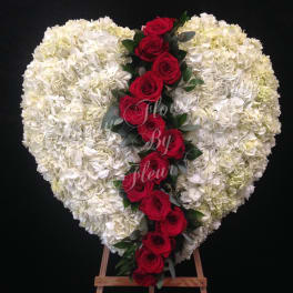 Heart-shaped white floral spray with a red rose cascade on an easel