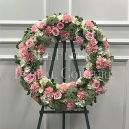 Pink and white floral wreath on a dark easel
