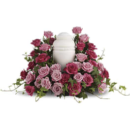 Pink and magenta roses arranged around a white urn