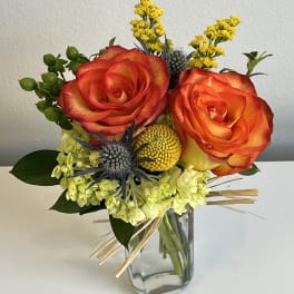 Bouquet of orange-red roses in a clear glass vase
