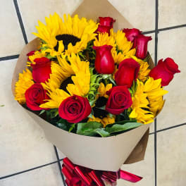 Bouquet of red roses and yellow sunflowers wrapped in brown paper