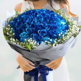 Large bouquet of blue roses with white filler flowers