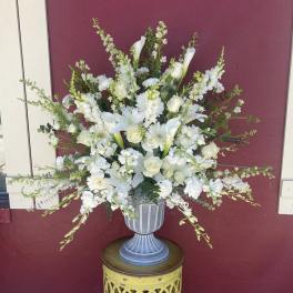White floral arrangement in a gray urn vase