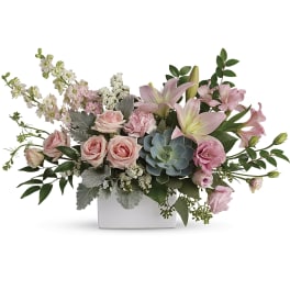 Pink roses and lilies arranged in a white rectangular vase