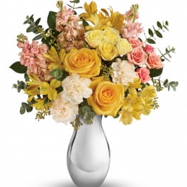 Yellow and pink flower bouquet in a clear glass vase