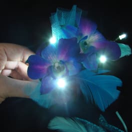 Blue-purple orchid corsage with small lights and feathers