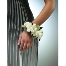 Woman wearing a white flower wrist corsage with green accents