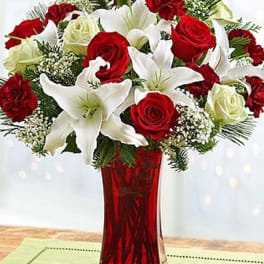 Red roses and white lilies arranged in a red vase