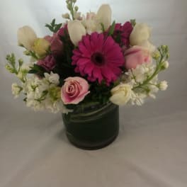 Pink and white mixed flower arrangement in a dark vase