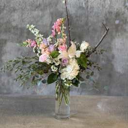 Mixed pastel flower arrangement in a clear glass vase