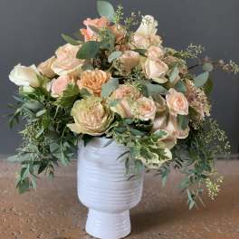 Peach and cream rose bouquet in a white vase