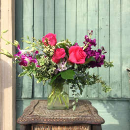 Pink roses and purple orchids in a glass vase