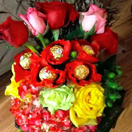 Bouquet of red and pink roses with wrapped chocolates